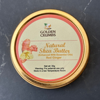 A round gold metal tin of Golden Crumbs Natural Shea Butter (Enhanced with Essential Oils) Red Ginger, shown on a dark gray marble surface.